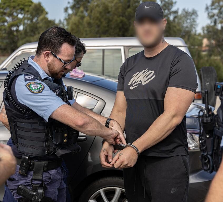 NSW police officer applying handcuffs on perp